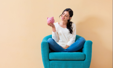 woman sitting in chair holding piggybank